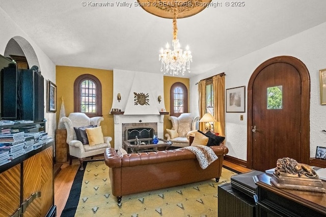 606 Fort Hill Dr, Charleston, WV 25314 - living area with arched walkways, a fireplace, a chandelier, and wood finished floors