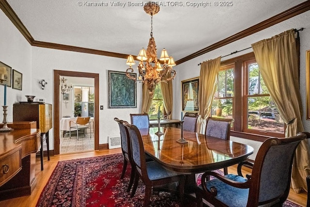 606 Fort Hill Dr, Charleston, WV 25314 - dining area featuring a chandelier, plenty of natural light, ornamental molding, light wood finished floors, and a textured ceiling