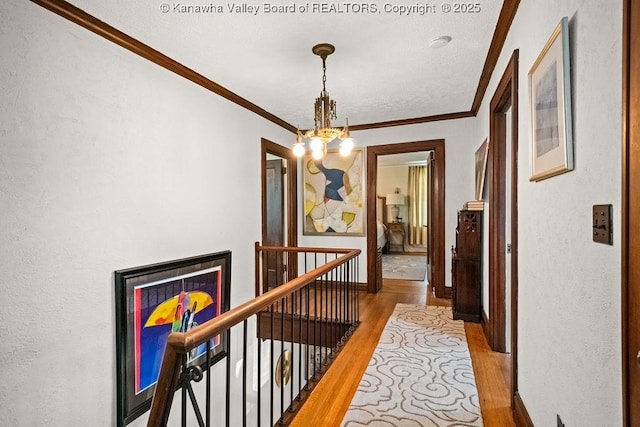 606 Fort Hill Dr, Charleston, WV 25314 - hallway featuring an upstairs landing, a chandelier, wood finished floors, ornamental molding, and a textured wall