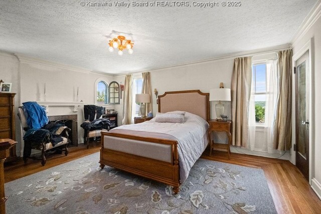 606 Fort Hill Dr, Charleston, WV 25314 - bedroom featuring multiple windows, a textured ceiling, wood finished floors, ornamental molding, and a fireplace