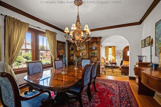 606 Fort Hill Dr, Charleston, WV 25314 - dining area featuring wood finished floors, arched walkways, a chandelier, a textured ceiling, and crown molding