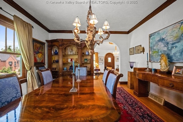 606 Fort Hill Dr, Charleston, WV 25314 - dining space featuring arched walkways, a chandelier, wood finished floors, crown molding, and a textured ceiling
