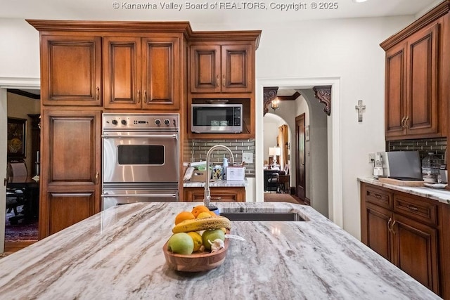606 Fort Hill Dr, Charleston, WV 25314 - kitchen featuring appliances with stainless steel finishes, a sink, light stone countertops, and tasteful backsplash