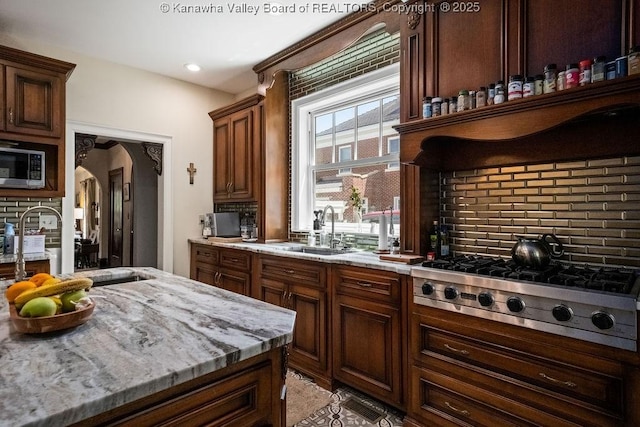 606 Fort Hill Dr, Charleston, WV 25314 - kitchen with a sink, appliances with stainless steel finishes, tasteful backsplash, arched walkways, and light stone countertops