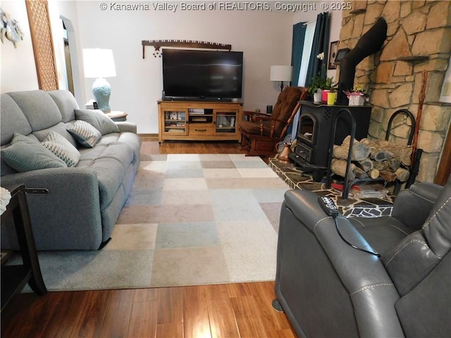 living room featuring wood finished floors and a wood stove