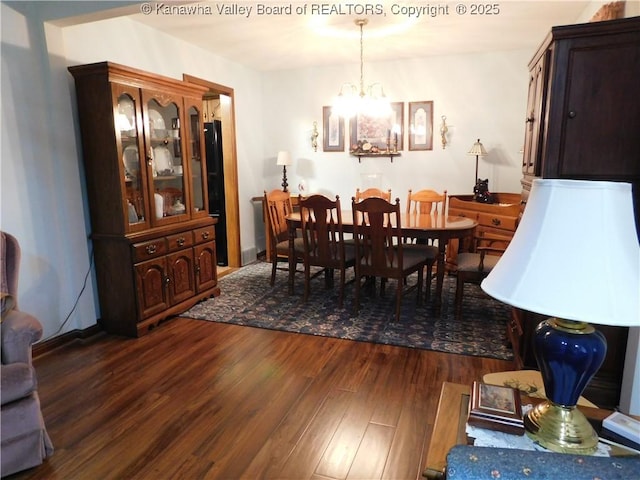 dining area with dark wood-type flooring and a chandelier
