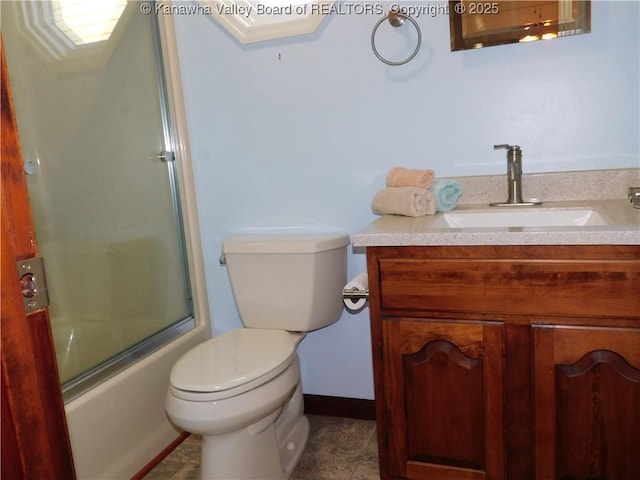 bathroom with toilet, vanity, combined bath / shower with glass door, and baseboards