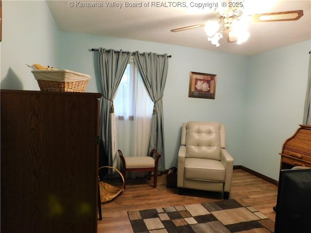 sitting room featuring wood finished floors, ceiling fan, and baseboards