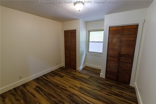 352 Hidden Valley Rd, Chapmanville, WV 25508 - unfurnished bedroom with multiple closets, baseboards, and dark wood finished floors