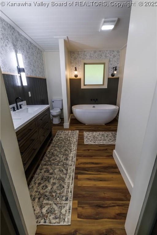 352 Hidden Valley Rd, Chapmanville, WV 25508 - full bath featuring wallpapered walls, a soaking tub, toilet, vanity, and wood finished floors