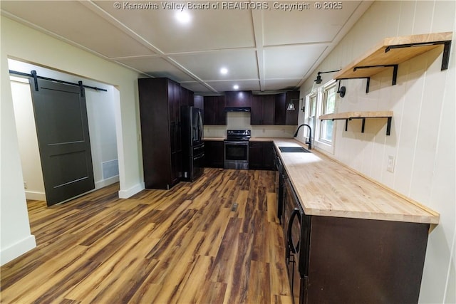 352 Hidden Valley Rd, Chapmanville, WV 25508 - kitchen with electric stove, a sink, black refrigerator with ice dispenser, wood finished floors, and a barn door