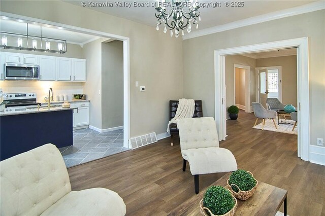 1505 Lee St E, Charleston, WV 25311 - living area featuring a chandelier, crown molding, dark wood-style floors, and baseboards