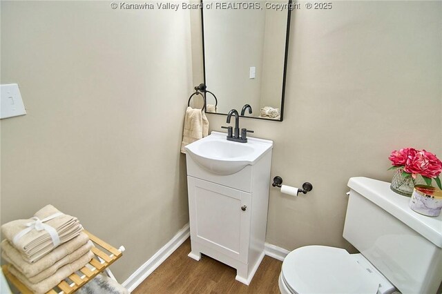 1505 Lee St E, Charleston, WV 25311 - bathroom with wood finished floors, baseboards, toilet, and vanity
