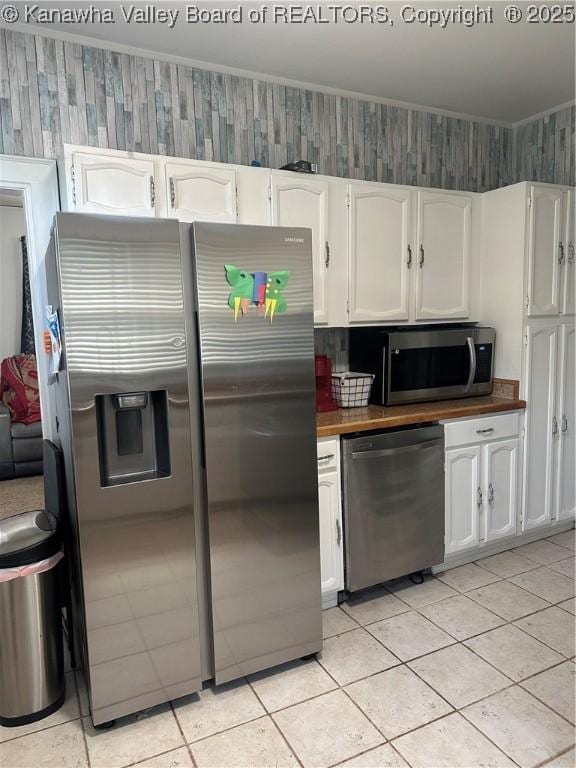 5505 Washington Ave, Charleston, WV 25304 - kitchen with appliances with stainless steel finishes, butcher block countertops, white cabinetry, light tile patterned flooring, and crown molding