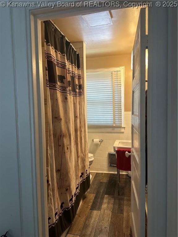 5505 Washington Ave, Charleston, WV 25304 - bathroom featuring toilet, wood finished floors, tile walls, a wainscoted wall, and curtained shower