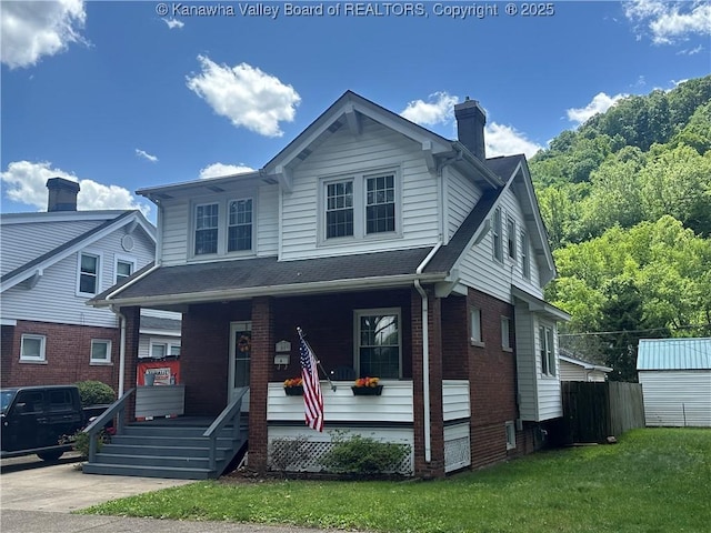 5505 Washington Ave, Charleston, WV 25304 - view of front facade with covered porch, a chimney, brick siding, and a front yard