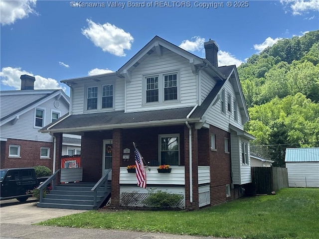 5505 Washington Ave, Charleston, WV 25304 - view of front of home with covered porch, a chimney, brick siding, and a front yard