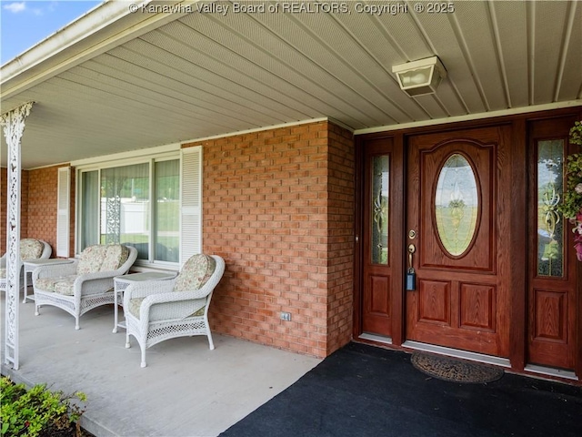property entrance with covered porch and brick siding