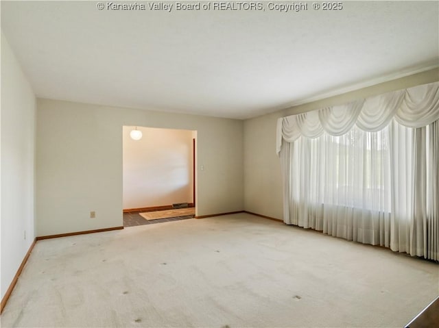 empty room with baseboards and carpet flooring