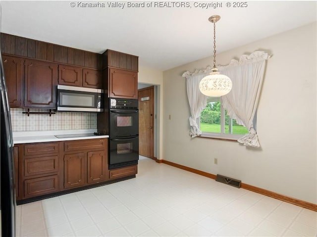 kitchen with black appliances, light countertops, baseboards, and pendant lighting