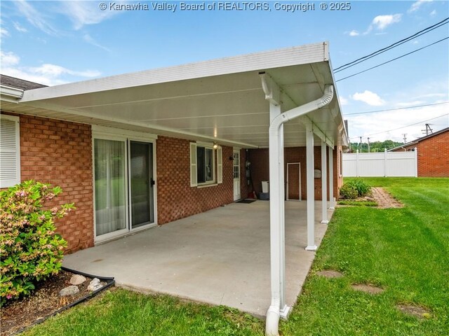 rear view of property with a patio area, brick siding, and a carport