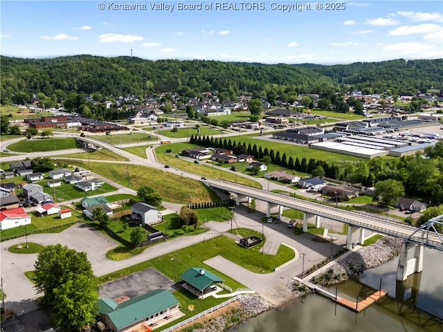 drone / aerial view of a heavily wooded area and a large body of water