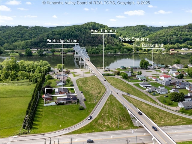 aerial view of property's location featuring a large body of water, property boundaries highlighted, and a heavily wooded area