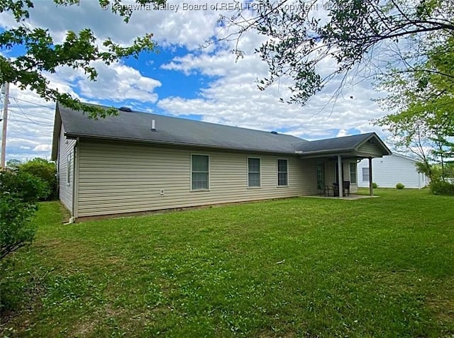 back of property with a yard and a patio