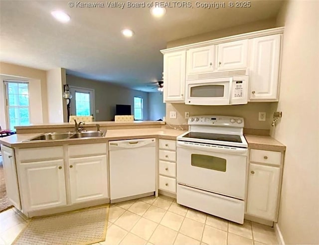kitchen featuring white appliances, a sink, recessed lighting, white cabinets, and light tile patterned floors