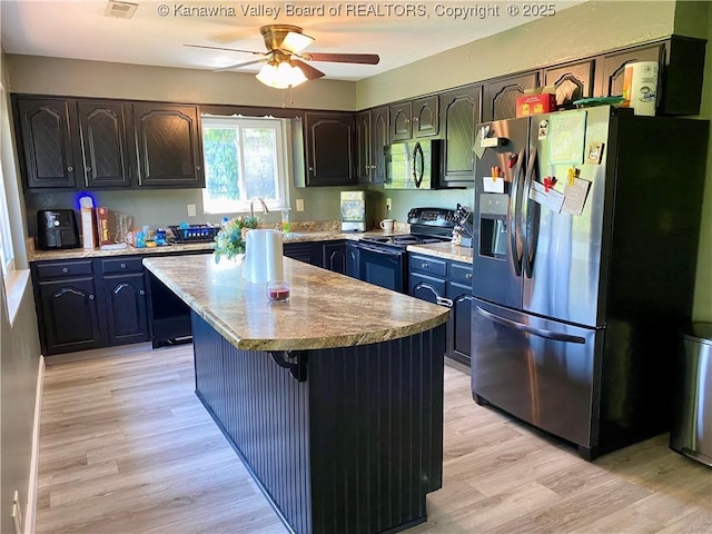 486 Woodland Acres Dr, Ripley, WV 25271 - kitchen with stainless steel appliances, light wood-style flooring, a ceiling fan, a center island, and light countertops