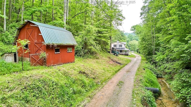 106 Coon Hollow Rd, Charleston, WV 25312 - view of yard featuring a barn, driveway, an outbuilding, and a wooded view