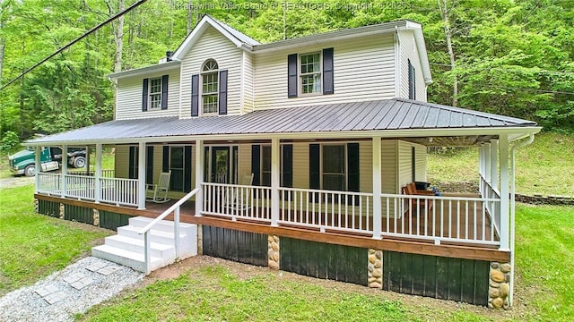 106 Coon Hollow Rd, Charleston, WV 25312 - farmhouse-style home with a porch, metal roof, a front yard, and a wooded view