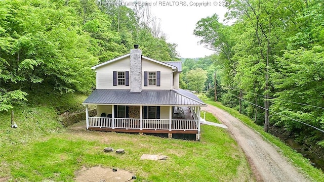 106 Coon Hollow Rd, Charleston, WV 25312 - farmhouse with a porch, dirt driveway, a chimney, and metal roof