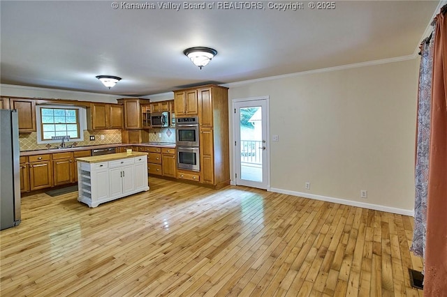 106 Coon Hollow Rd, Charleston, WV 25312 - kitchen with appliances with stainless steel finishes, a sink, ornamental molding, brown cabinetry, and backsplash