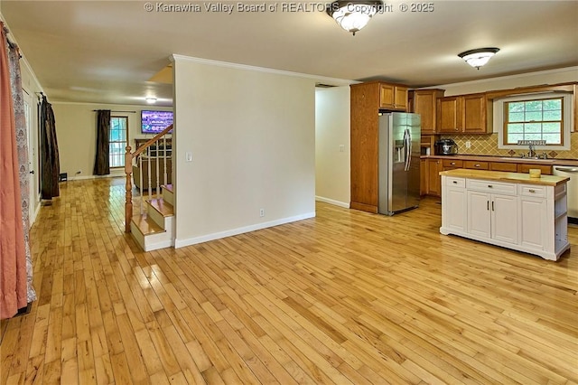 106 Coon Hollow Rd, Charleston, WV 25312 - kitchen with stainless steel refrigerator with ice dispenser, light wood-style floors, backsplash, crown molding, and light countertops