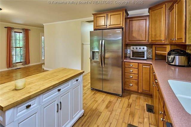 106 Coon Hollow Rd, Charleston, WV 25312 - kitchen featuring stainless steel fridge, wooden counters, ornamental molding, light wood-style flooring, and tasteful backsplash