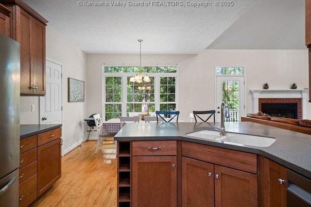 16 Pinnacle Dr, Charleston, WV 25311 - kitchen featuring a sink, freestanding refrigerator, a chandelier, dark countertops, and brown cabinetry