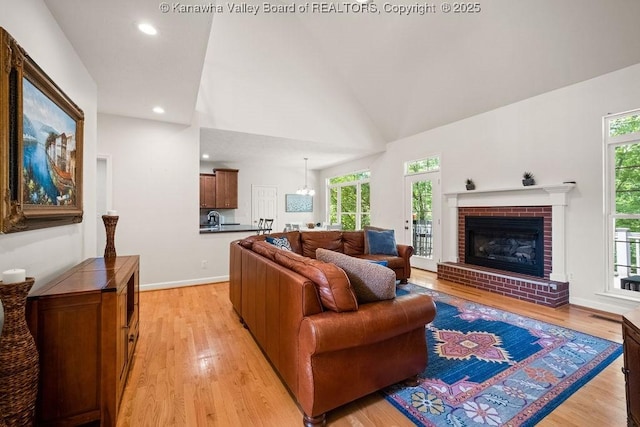 16 Pinnacle Dr, Charleston, WV 25311 - living room with light wood finished floors, lofted ceiling, recessed lighting, a brick fireplace, and baseboards