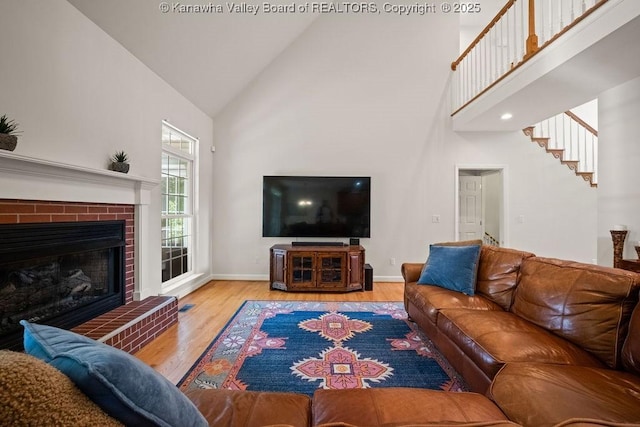16 Pinnacle Dr, Charleston, WV 25311 - living area featuring high vaulted ceiling, wood finished floors, baseboards, a fireplace, and stairs