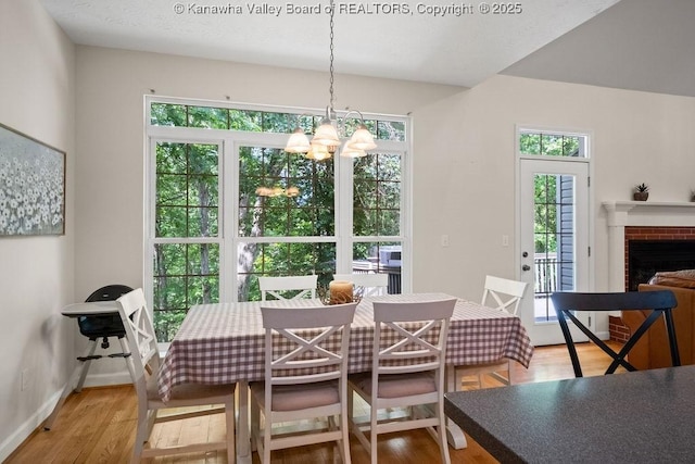 16 Pinnacle Dr, Charleston, WV 25311 - dining room with a chandelier, light wood-style floors, baseboards, and a brick fireplace