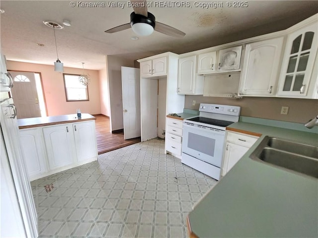 1605 Dunbar Ave, Dunbar, WV 25064 - kitchen with white electric range oven, a sink, white cabinetry, a ceiling fan, and decorative light fixtures