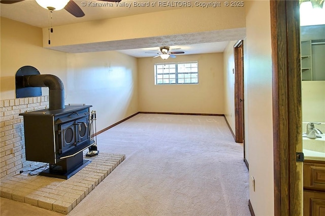100 Timberlake Cir, Scott Depot, WV 25560 - unfurnished living room with a ceiling fan, light colored carpet, a wood stove, and a sink