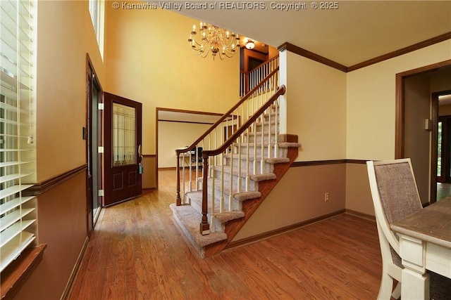 9 Shamblin Pl, Charleston, WV 25314 - entrance foyer featuring a chandelier, stairs, wood finished floors, baseboards, and crown molding