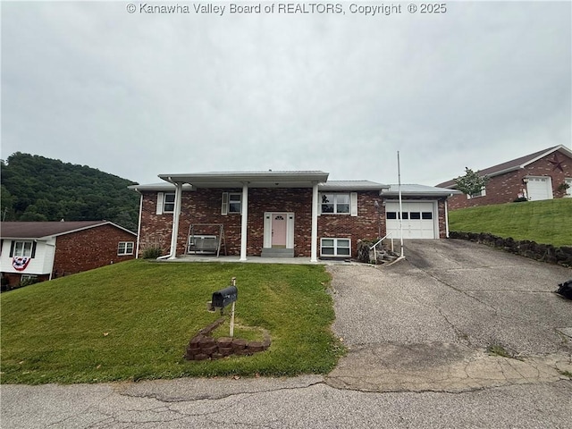 40 Hickory Ln, Madison, WV 25130 - raised ranch with an attached garage, driveway, a front lawn, and brick siding