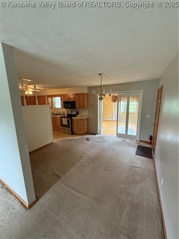 40 Hickory Ln, Madison, WV 25130 - unfurnished living room featuring light carpet, a textured ceiling, a chandelier, baseboards, and a sink