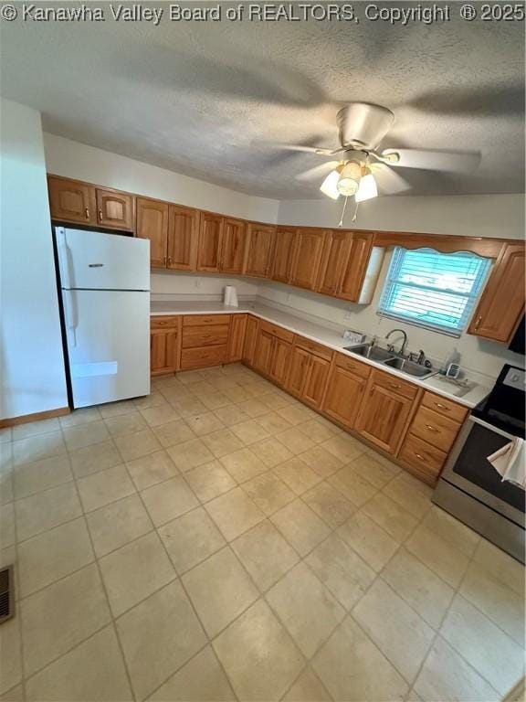 40 Hickory Ln, Madison, WV 25130 - kitchen with freestanding refrigerator, stainless steel range oven, a sink, light countertops, and a textured ceiling