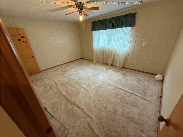 40 Hickory Ln, Madison, WV 25130 - carpeted empty room featuring a ceiling fan, wooden walls, baseboards, and a textured ceiling