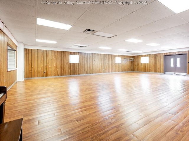 463 Gap View Dr, Charleston, WV 25326 - unfurnished room featuring light wood-type flooring, plenty of natural light, a paneled ceiling, baseboards, and wood walls