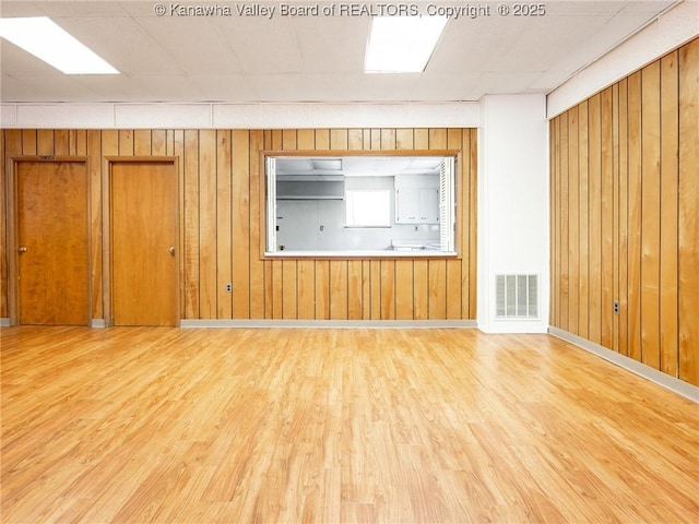 463 Gap View Dr, Charleston, WV 25326 - unfurnished living room with light wood-type flooring, wooden walls, and baseboards