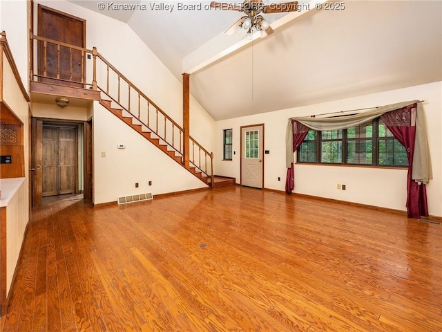 1799 Fishers Branch Rd, Charleston, WV 25312 - unfurnished living room featuring a ceiling fan, high vaulted ceiling, wood finished floors, stairs, and baseboards